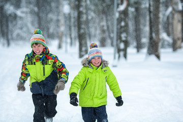 cheerful happy boys playing in winter park,
