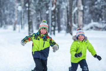 Fototapeta na wymiar cheerful happy boys playing in winter park,