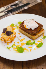 Dish with meat steak on toast, potato chips  melted cheese and poached egg  Dutch sauce. Wooden background. Top view. Close-up