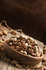 Nuts mix, healthy and beneficial food, vintage wooden background