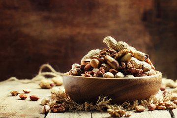 Nuts mix, healthy and beneficial food, vintage wooden background