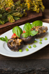 Stuffed champignon quail eggs with basil and tomatoes. Wooden background. Close-up