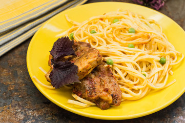 Meat with spaghetti and peas. Top view. Close-up