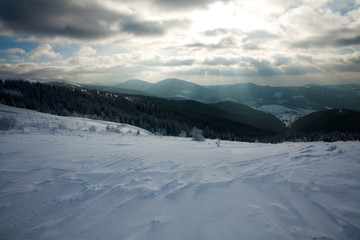 Winter landscape of mountains in rays of the setting sun