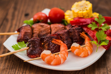 Skewers of smoked salmon on  with prawns and vegetables