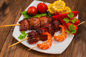Skewers of smoked salmon on  with prawns and vegetables