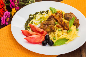 Tagliolini with meat in tomato sauce, olives and   spinach. Wooden background. Close-up. Top view