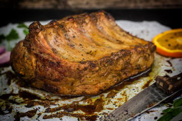 Baked pork ribs with sauce and basil on a black table. Top view. Close-up. Selective focus