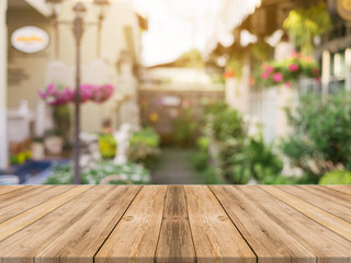 Wooden board empty table top on of blurred background. Perspective brown wood table over blur in...