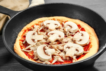 Unbaked pizza in pan, closeup