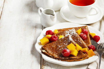 Crepes with fresh mango and raspberries