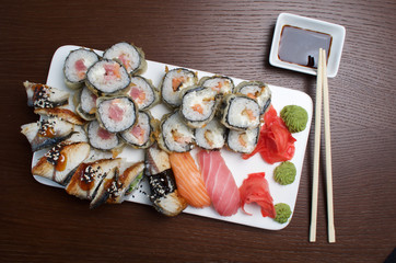 Sushi and rolls on white plate with soy sauce
