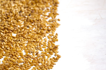 Golden flax on white wojden background