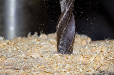 Wood drill in action; saw dust flying around