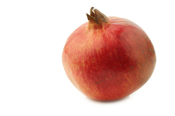 one whole pomegranate(Punica granatum)on a white background