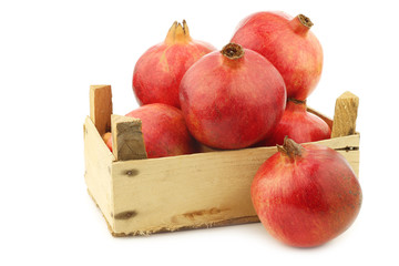 pomegranate(Punica granatum) in a wooden crate on a white background