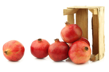 pomegranate(Punica granatum) in a wooden crate on a white background