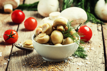 Marinated mushrooms, vintage wooden background, selective focus