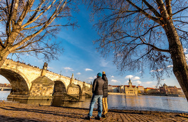 Naklejka premium Couple of young people looking at Charles Bridge in Prague, Bohemia, Czech Republic