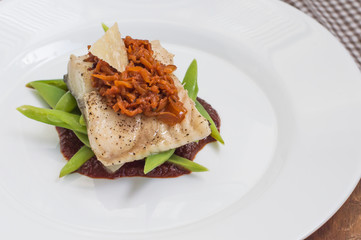 Cooked fish with steamed asparagus, vegetable ragout, tomato sauce and potato chips. Wooden background. Top view. Close-up