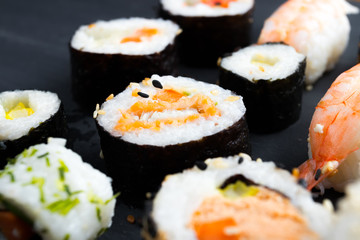 Japanese sushi on black kitchen slate plate.