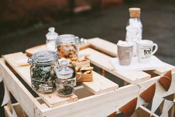 Christmas street decorations with cookies, cacao, handmade wooden table, little flags and baubles and a red brick wall