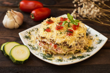 The cake of zucchini with cheese, tomato and basil. Wooden background. Close-up
