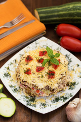 The cake of zucchini with cheese, tomato and basil. Wooden background. Top view. Close-up