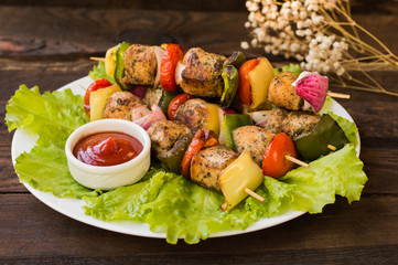 Skewers of chicken and vegetables on wooden . Rural background. Close-up