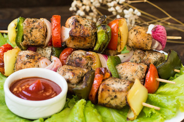 Skewers of chicken and vegetables on wooden . Rural background. Close-up