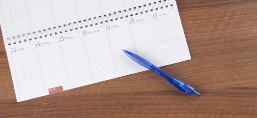 Workplace in office with calendar and pen