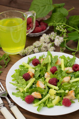 Salad with raspberries, arugula, cucumber, paprika, roasted chicken and sesame. Wooden background. Close-up