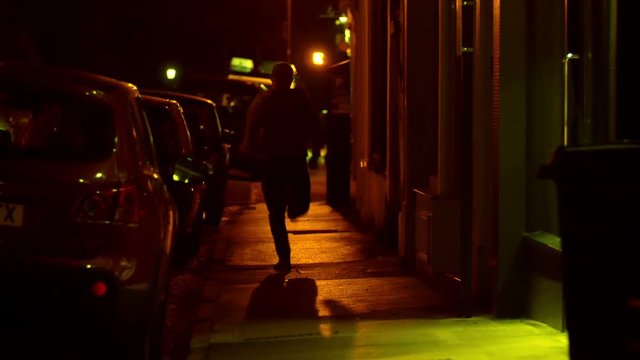 thied running away in the street during the night, someone follows him