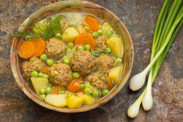 Soup with meatballs, carrots and peas. Old background. Top view. Close-up