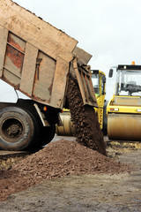 Construction truck unloads ground to the  site and road widening