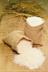 Rice in gunny bag on wooden surfaces in the side view.