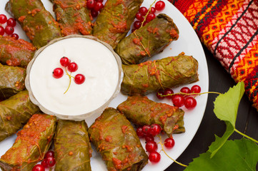 Dolma - this grape leaves stuffed with rice-based, as well  boiled minced meat. It is common in kitchens Caucasus, the Balkans, Asia and North Africa.Wooden background. Top view. Close-up