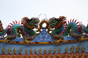 Ancient metal colorful double of Sculpture dragon flying art crafting isolated on light blue sky...