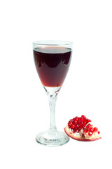 Pomegranate juice in a wine glass and ripe pomegranate
