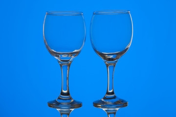 Two wine glasses on blue background