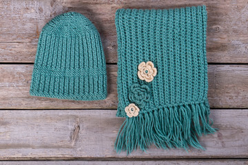 Wool scarf and hat on a wooden background.