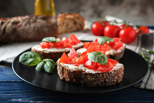 Delicious bruschetta with tomatoes on black plate