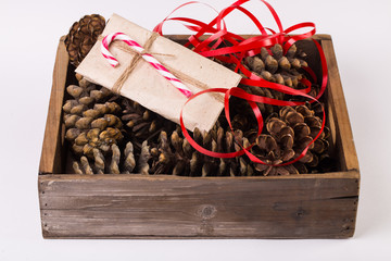 Christmas gift tied with ribbon and pine cone isolated on white background