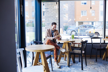 Fototapeta na wymiar Man Sitting in Coffee Shop