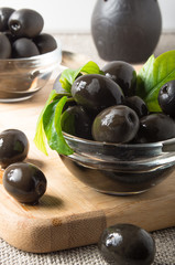 Black olives in a glass bowl on an old table cloth