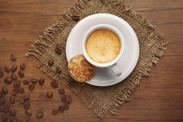 Cup of coffee and cookie on wooden background