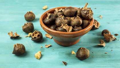 Roasted chestnuts in earthenware bowl on turquoise