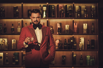 Extravagant stylish man with whisky glass in gentleman club