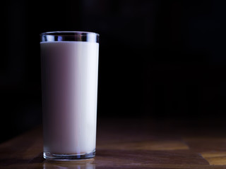 glass of milk on wooden table. Benefits of Drinking milk concept.