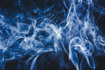 Artistic blue smoke on black background texture.